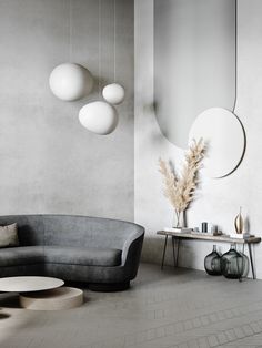 a living room filled with furniture next to a wall mounted mirror and two round mirrors