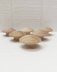 four wooden bowls sitting on top of a white table