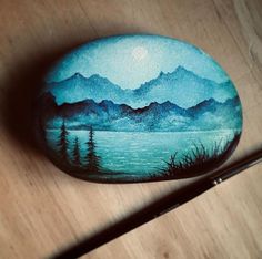 a painted rock sitting on top of a wooden table