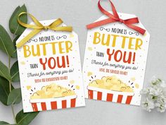 two tags that say no one is butter you and have popcorn on them with red bows