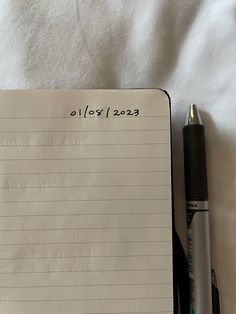 a notepad with writing on it next to a pen