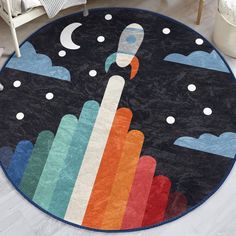 a round rug with an image of a rocket ship in the sky and clouds on it