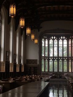 the interior of a large building with many tables and lamps hanging from it's ceiling