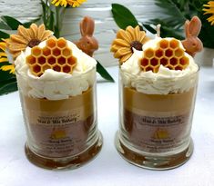 two jars filled with cake and frosting topped with honeycombs, bunny ears and flowers