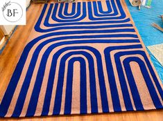 a blue and beige rug on the floor in a room with other items around it