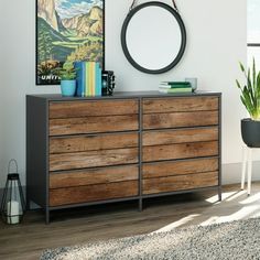 a wooden dresser sitting next to a window in a room with a painting on the wall