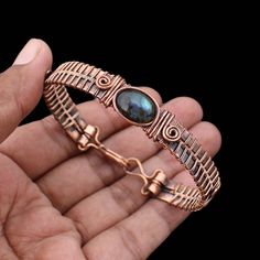 Labradorite Cuff Bracelet Copper Wire Wrapped Bangle Natural Labradorite Jewelry Gemstone Adjustable Bangle Handmade Wire Wrapped Jewelry Main Stone - Labradorite Bangle Length - 2.50 - 2.75" Inches (Adjustable) Bangle Width  -  0.50 Inches Metal                  -  Copper Copper Has Been Used For Jewelry Making For Thousands Of Years, Dating Back To Ancient Civilizations Such As The Egyptians, Romans, And Aztecs. Copper Was Valued For Its Beauty, Versatility, And Durability, And Was Often Used Adjustable Labradorite Bracelet With Unique Style, Handmade Labradorite Artisan Bracelets, Handmade Artisan Labradorite Bracelets, Adjustable Labradorite Bangle Bracelet, Handmade Labradorite Bohemian Bracelets, Handmade Labradorite Bangle Jewelry, Artisan Labradorite Bracelets For Gifts, Hand Wrapped Labradorite Bracelets As Gift, Bohemian Round Labradorite Bracelets