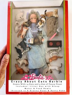 a barbie doll in a box with lots of cats and dogs on it's back