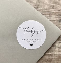 a thank you sticker on top of a gray envelope