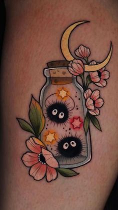 a tattoo with flowers and stars in a jar