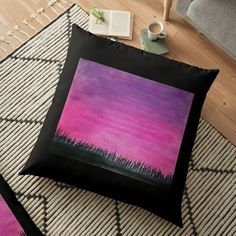 a pink and purple painting on a black pillow