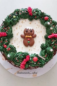 a decorated christmas cake on a white plate with green frosting and sprinkles