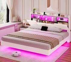 a white bed with pink lights on the headboard and foot board in front of it