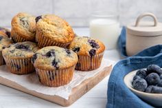 some blueberry muffins are on a wooden board