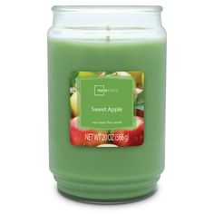 a green candle with an apple label on the front and side, sitting in front of a white background