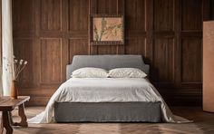 a bedroom with wood paneled walls and a bed