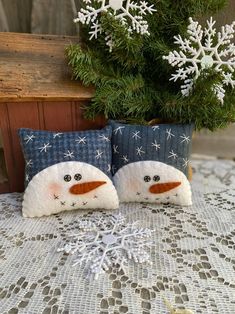 two snowmen sitting next to each other on a table