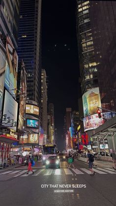 a city street filled with lots of traffic and tall buildings at night time, with people crossing the street