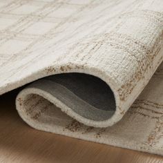 a close up view of a rug on the floor with a white and brown pattern