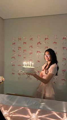 a woman holding a cake with lit candles