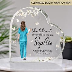 a personalized glass plaque with a woman in blue scrubs and flowers on it