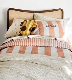 a bed with orange and white striped pillows