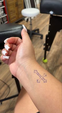 a woman's arm with a tattoo on it and two crossed crosses in the middle