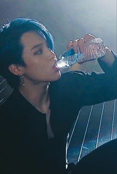 a woman drinking water from a plastic bottle