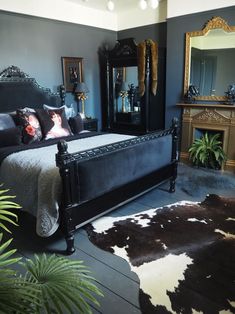 a bed room with a neatly made bed next to a mirror and potted plant