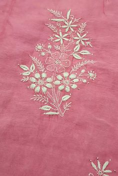 an embroidered pink cloth with white flowers on it