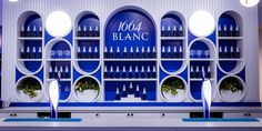 a blue and white display with bottles on it's shelves in front of the counter