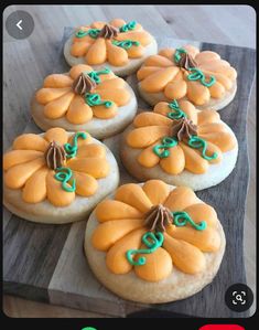 some cookies with icing are on a wooden board