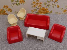 red and white furniture sitting on top of a carpeted floor next to a wall