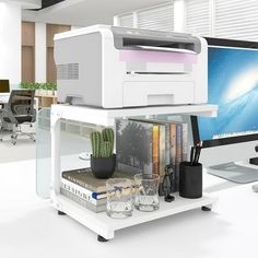 there is a computer and printer on top of each other in an office space with desks