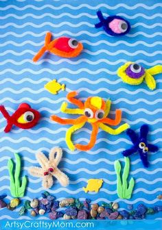 an assortment of sea animals made out of pipe cleaners and plastic beads on a blue background