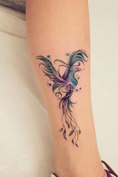 a woman's foot with a bird tattoo on the left side of her leg