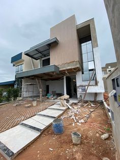 a house being built on the side of a dirt road with stairs leading up to it