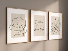 three framed art pieces hang on the wall next to each other, one with a woman's breast