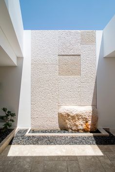 a white building with a stone bench next to it