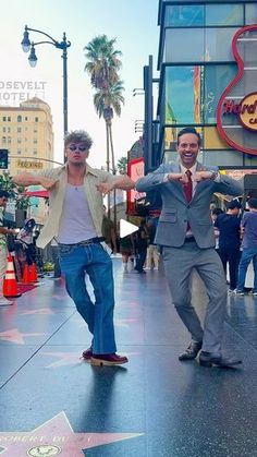 two men on skateboards in front of the hollywood walk of fame