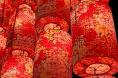 many red and yellow paper lanterns with flowers on them