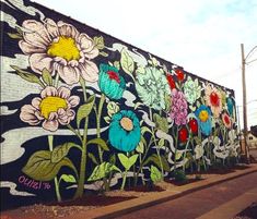 a large mural on the side of a building with flowers and leaves painted on it