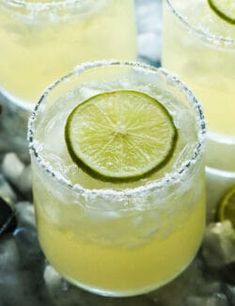 three glasses filled with lemonade and lime slices