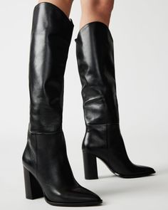 A pointed toe and curved topline give the BIXBY block heel knee boot a Western edge while the sleek upper highlights the clean monochrome look Point toe block heel knee boot Slip-on style Curved topline 3.5 inch heel height Size 6 measurements: 15.5 inch shaft circumference, 14.25 inch shaft height Size 8 measurements: 16 inch shaft circumference, 15 inch shaft height Size 10 measurements: 17 inch shaft circumference, 15.5 inch shaft height Leather upper material Synthetic and textile lining Syn Knee High Boots Petite, Knee High Brown Leather Boots, Black Leather Knee High Boots, Steve Madden Store, Knee Boot, Fashion Icons, Platform Sandals Heels, Black Knees, 5 Inch Heels