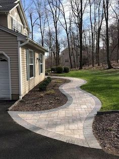 a driveway with a walkway leading to a garage