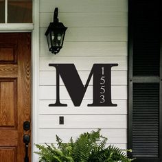 the front door of a house with a lamp and potted plant next to it