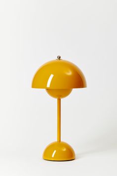 a yellow table lamp sitting on top of a white floor