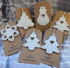 six white christmas ornaments are on brown tags