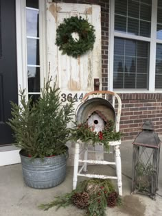 a white chair sitting on top of a porch next to a planter filled with pine cones