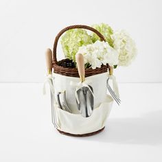 a basket with utensils and flowers in it